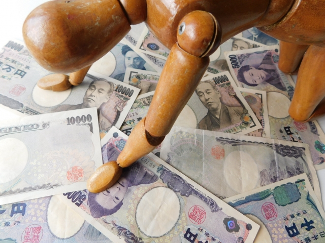お金の上でうなだれる。つくばみらい市で借金返済の無料相談をする