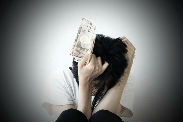 お金を手に頭を抱える。つくばみらい市で弁護士や司法書士に債務整理の無料相談をする